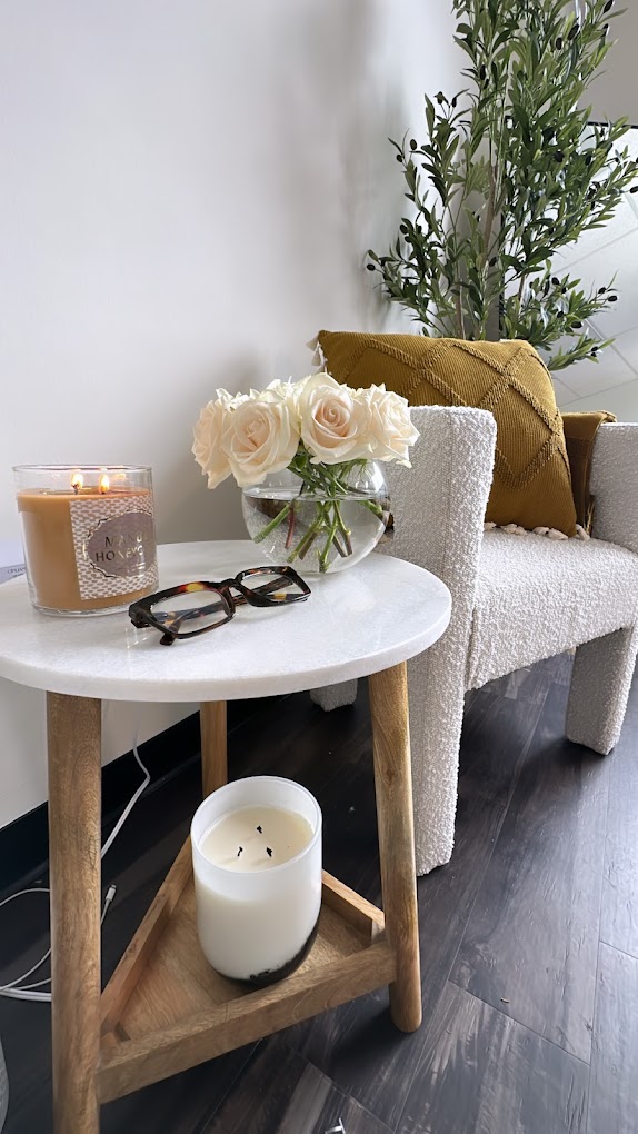 Seating corner with candles and flowers inside the Nirvana Skin Co. studio